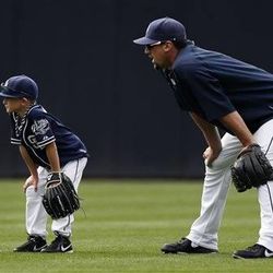 Trey Kotsay, left, the son of San Diego Padres left fielder Mark Kotsay, waits to field balls alongside Padres pitcher Luke Gregerson before the Padres face the Toronto Blue Jays in an interleague baseball game, Saturday.