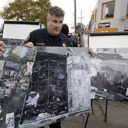 Alameda County Sheriff J.D. Nelson holds an aerial picture of a warehouse fire near the site Monday, Dec. 5, 2016, in Oakland, Calif. The death toll in the fire climbed Monday with more bodies still feared buried in the blackened ruins, and families anxiously awaited word of their missing loved ones. 