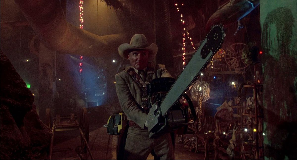 Dennis Hopper wears a cowboy hat and has a gigantic chainsaw in The Texas Chainsaw Massacre 2.
