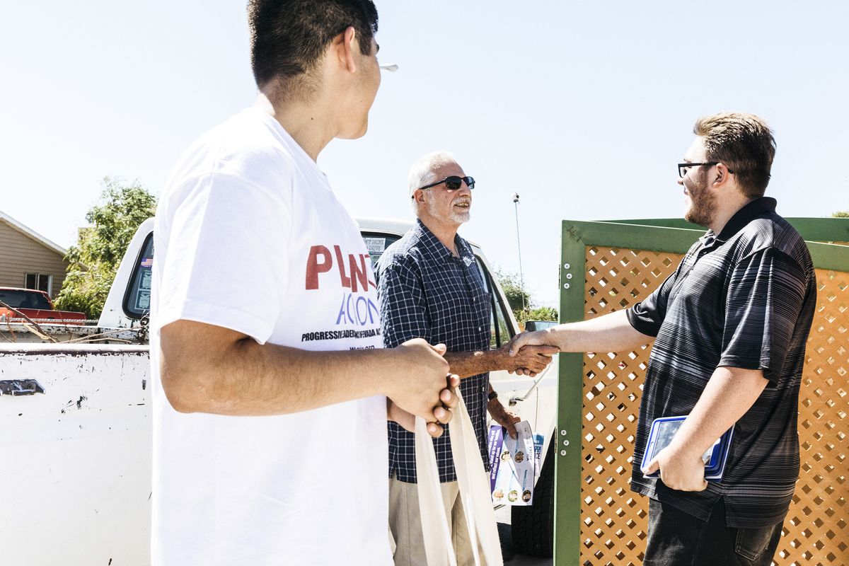 Left, Steven Camacho, 16, &amp; Tristian Brower, 18, talk with resident Ronald Carter while canvassing a neighborhood in Las Vegas, Nev. on September 15, 2018.
