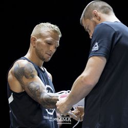 T.J. Dillashaw puts on his gloves at the UFC 227 open workouts in Los Angeles, California.