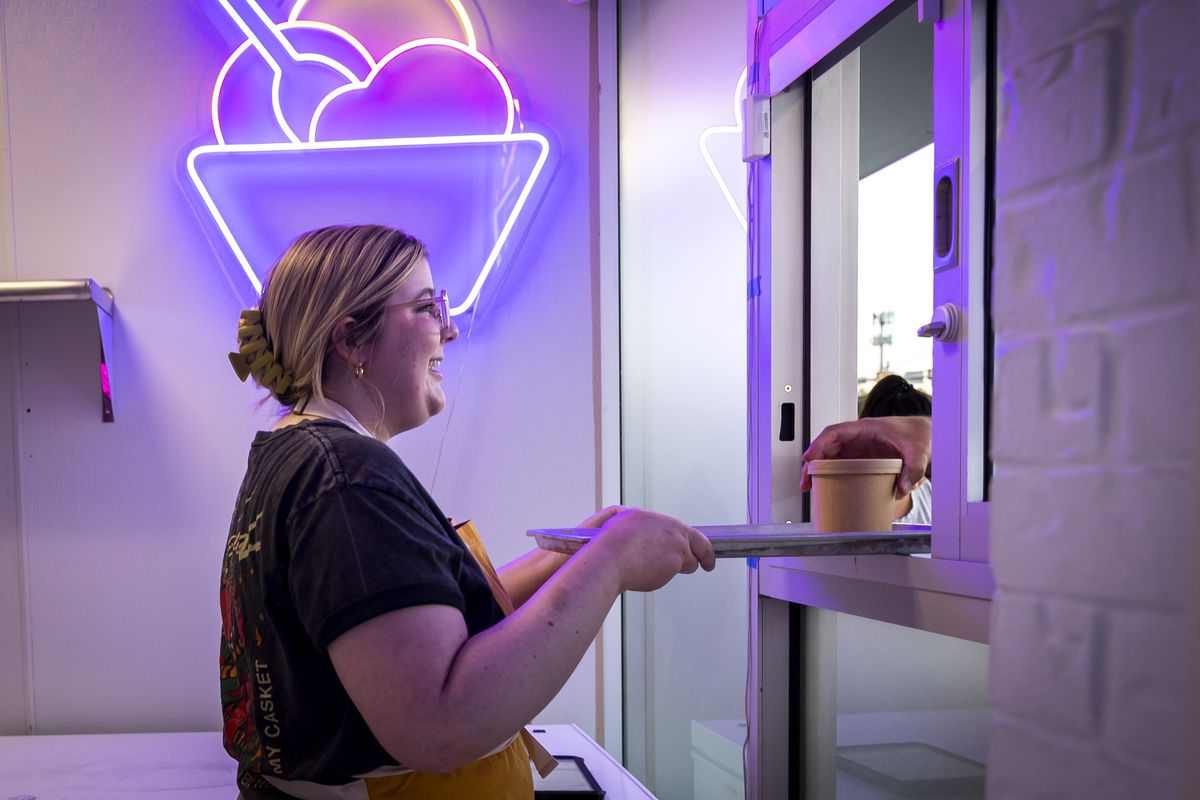 Emmy Walling hands a customer their ice cream order at Underground Creamery on Monday, Sept. 26, 2022.