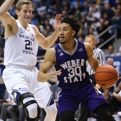 Weber State Wildcats guard Jeremy Senglin (30) drives around Brigham Young Cougars forward Kyle Davis (21) as BYU and Weber State play at the Marriott Center in Provo on Wednesday, Dec. 7, 2016.