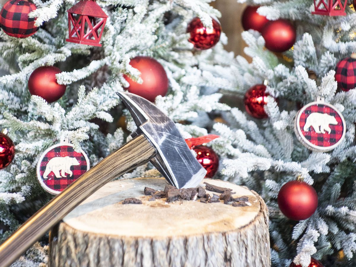A Christmas tree beside a lumberjack axe.
