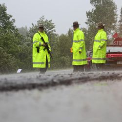 New York State Police troopers stand in the heavy rain at a roadblock as the search continues for two prison escapees from Clinton Correctional Facility in Dannemora, on Tuesday, June 23, 2015, in Malone, N.Y.  Police began focusing intensely on the area 20 miles west of the prison that inmates David Sweat and Richard Matt escaped on June 6. 