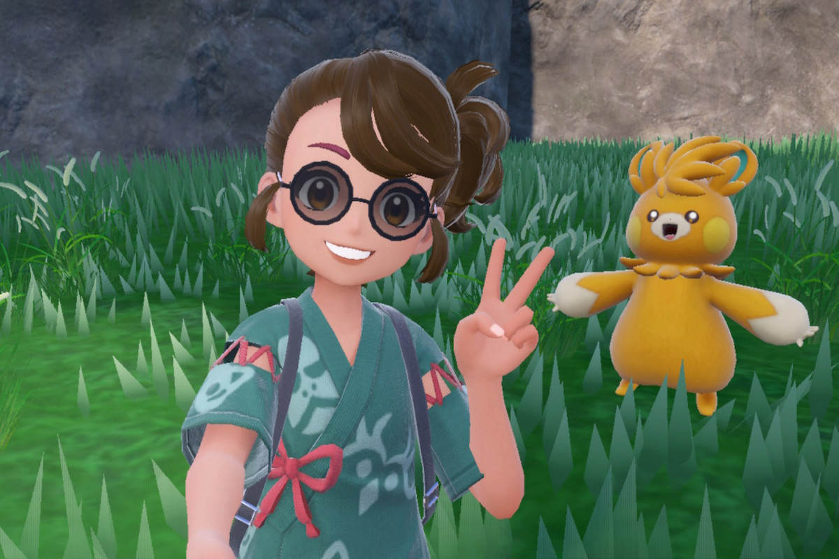 An image of trainer in Pokémon  using a selfie stick to take a selfie. She’s holding up a peace sign in front of Pawmot. 