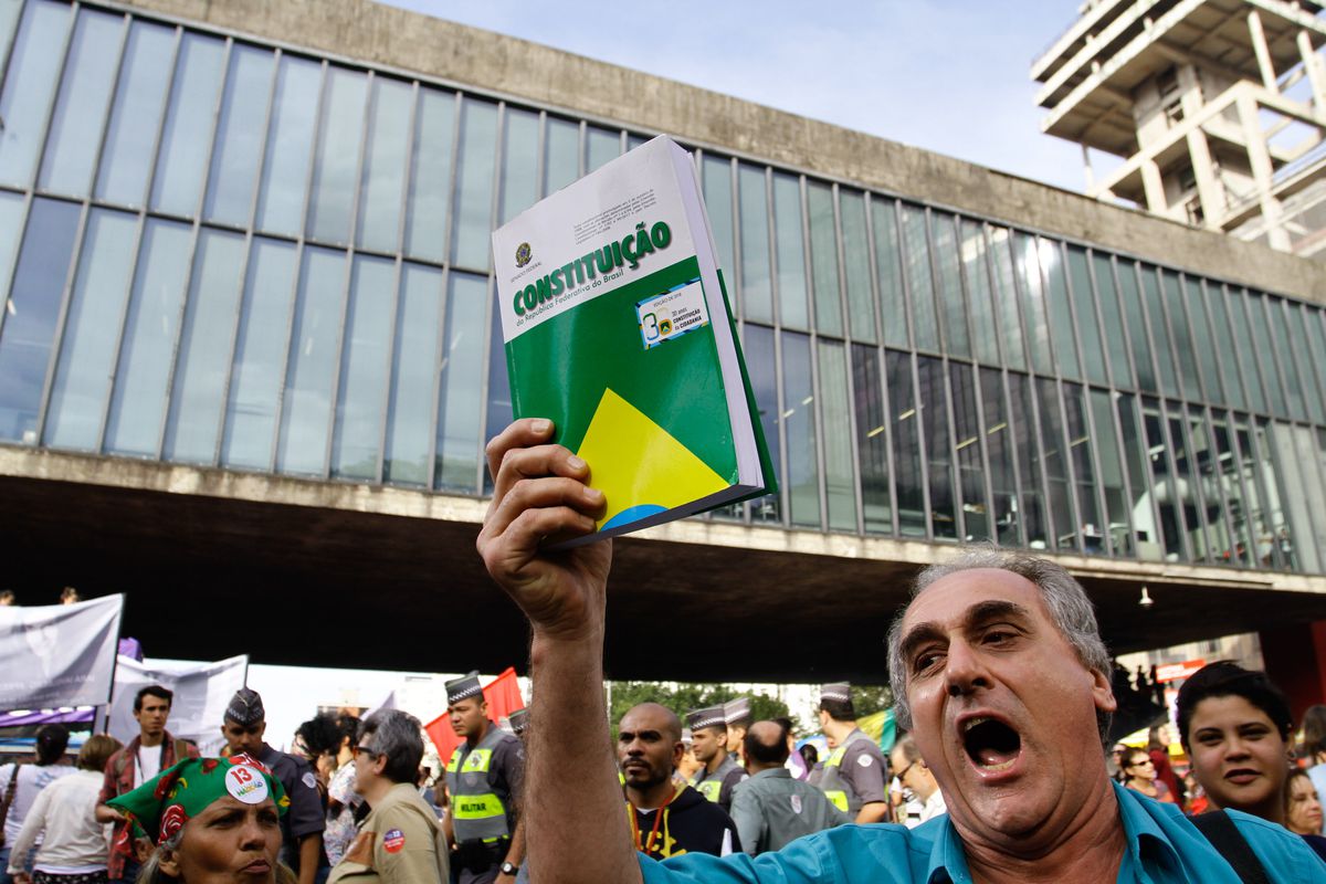 A protestor in Sao Paolo, Brazil, holds up a copy of the Brazilian Constitution.