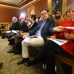 Salt Lake City Councilman Charlie Luke hands out releases to other council members as Mayor Jackie Biskupski and City Councilman James Rogers announce the sites for four new homeless resource centers to be built around the city. The announcement was made during a press conference at the City-County Building on Tuesday, Dec. 13, 2016.
