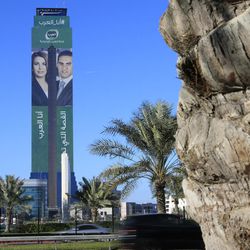 Advertising on the side of a skyscraper shows news anchors for the newly launched Alarab TV network, in Manama, Bahrain, Monday, Feb. 2, 2015. The new pan-Arab news channel backed by billionaire Saudi Prince Alwaleed bin Talal, was suspended from broadcasting from its home in Bahrain on Monday, just hours after it went on air and carried an interview with prominent Bahraini opposition activist, Khalil al-Marzooq. Arabic writing on the tower reads: "I am Alarab," and "The story that concerns you." 