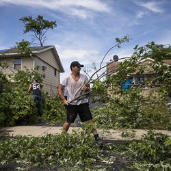 Chris Bryant, 39, whose mom lives in Woodridge, helps residents clear out fallen trees on Chestnut Avenue near Evergreen Lane in Woodridge, after a tornado ripped through the western suburbs overnight, Monday morning, June 21, 2021.