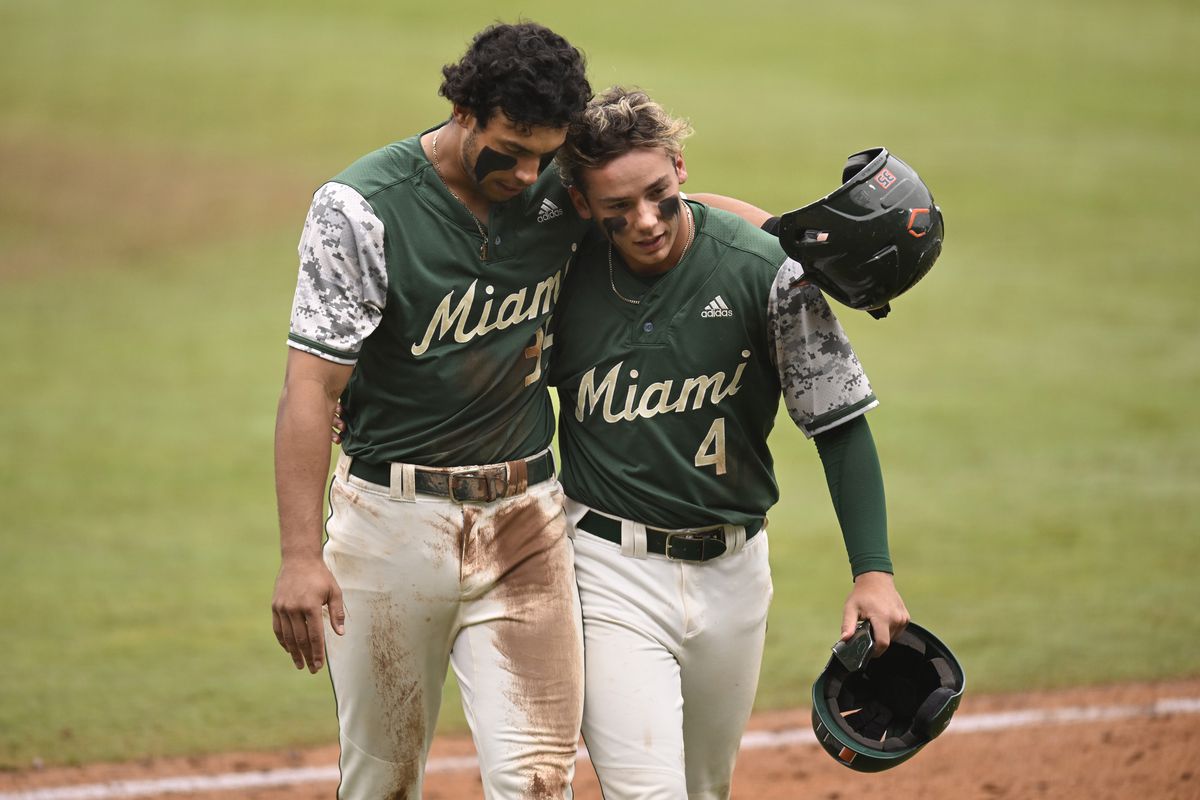 Yohandy Morales and Blake Cyr of the Miami Hurricanes walk to to dugout as the Clemson Tigers change pitchers in the fifth inning during the ACC Baseball Championship game at Durham Bulls Athletic Park on May 28, 2023 in Durham, North Carolina.