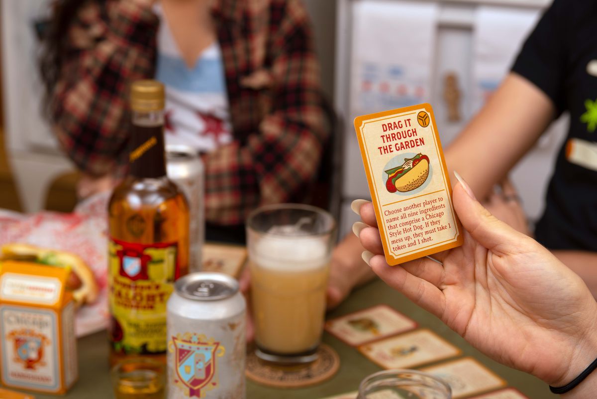 One of the game’s tasks is to name all nine ingredients of the Chicago-style hot dog, a feat that may prove more challenging when intoxicated. A player holds up the card