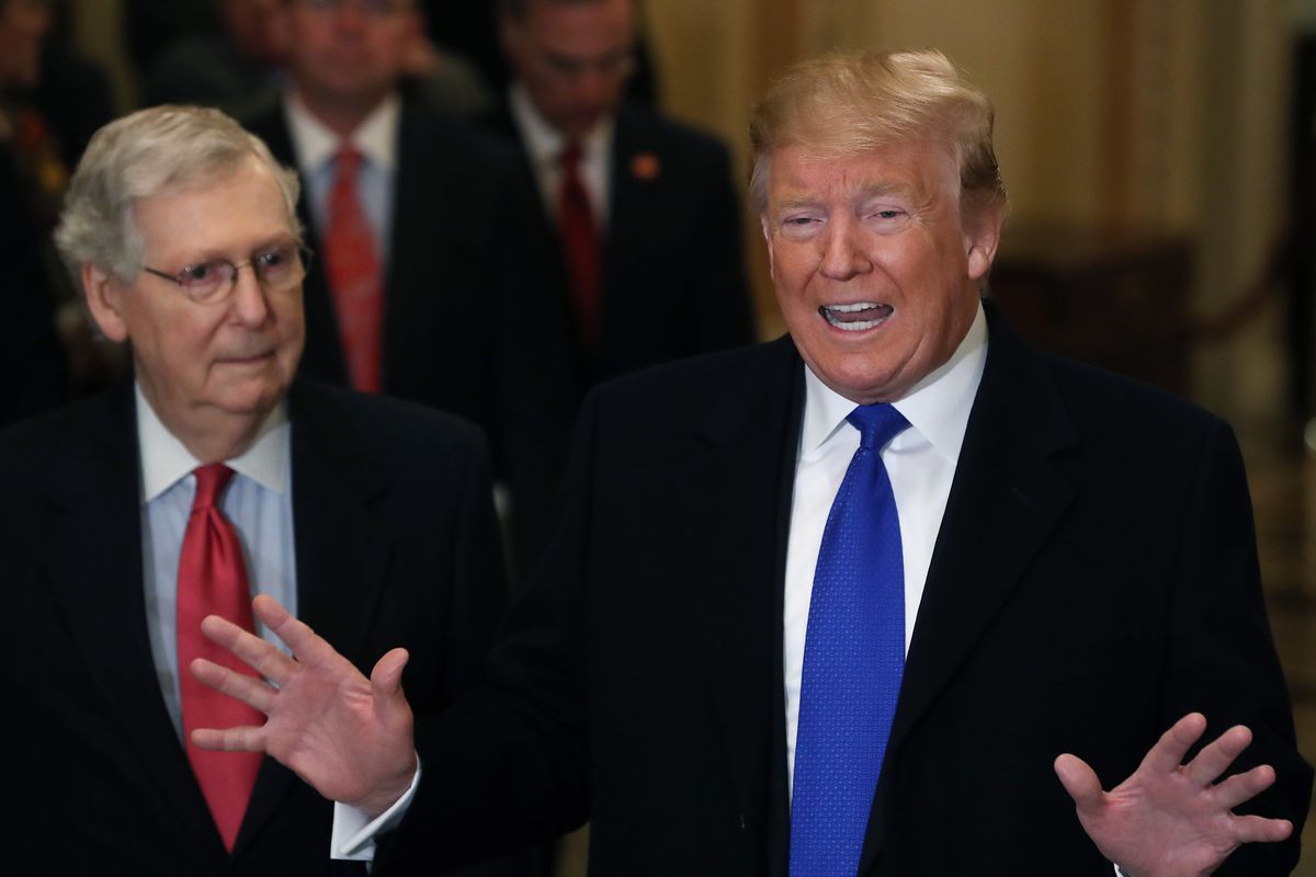 President Donald Trump standing and speaking beside Senate Majority Leader Mitch McConnell.