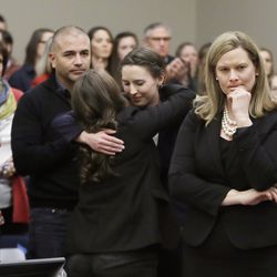 Former gymnast Rachael Denhollander, center, is hugged after giving her victim impact statement during the seventh day of Larry Nassar's sentencing hearing Wednesday, Jan. 24, 2018, in Lansing, Mich. At right is Assistant Attorney General Angela Povilaitis. Nassar has admitted sexually assaulting athletes when he was employed by Michigan State University and USA Gymnastics, which is the sport's national governing organization and trains Olympians. (AP Photo/Carlos Osorio)