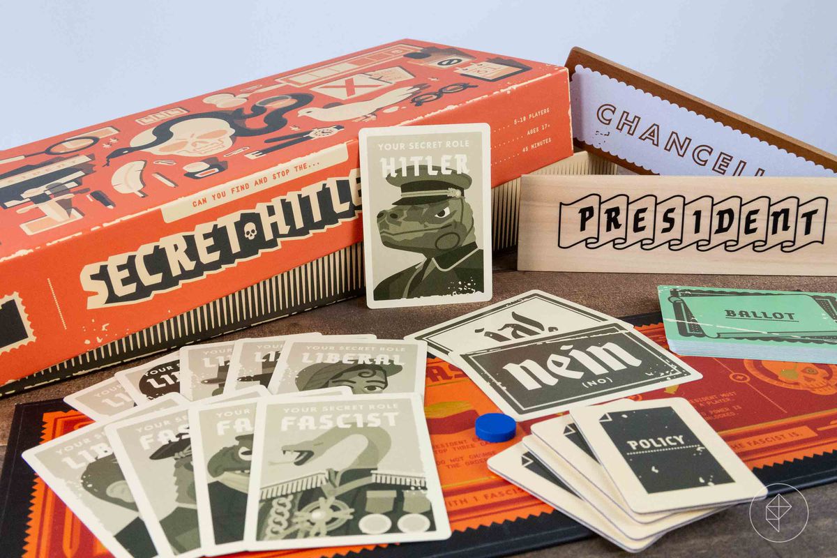 The components for Secret Hitler, including a card that says “Your secret role is Hitler” and a picture of a lizard man.