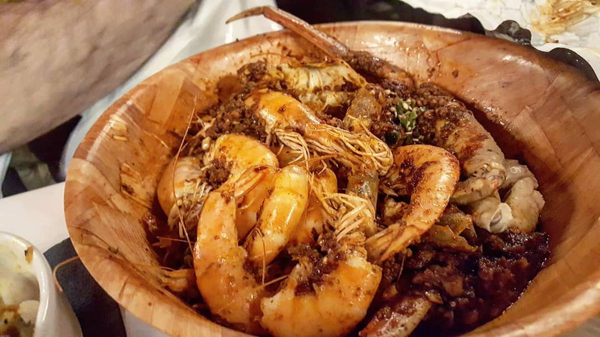 A wooden bowl filled with Cajun-seasoned seafood
