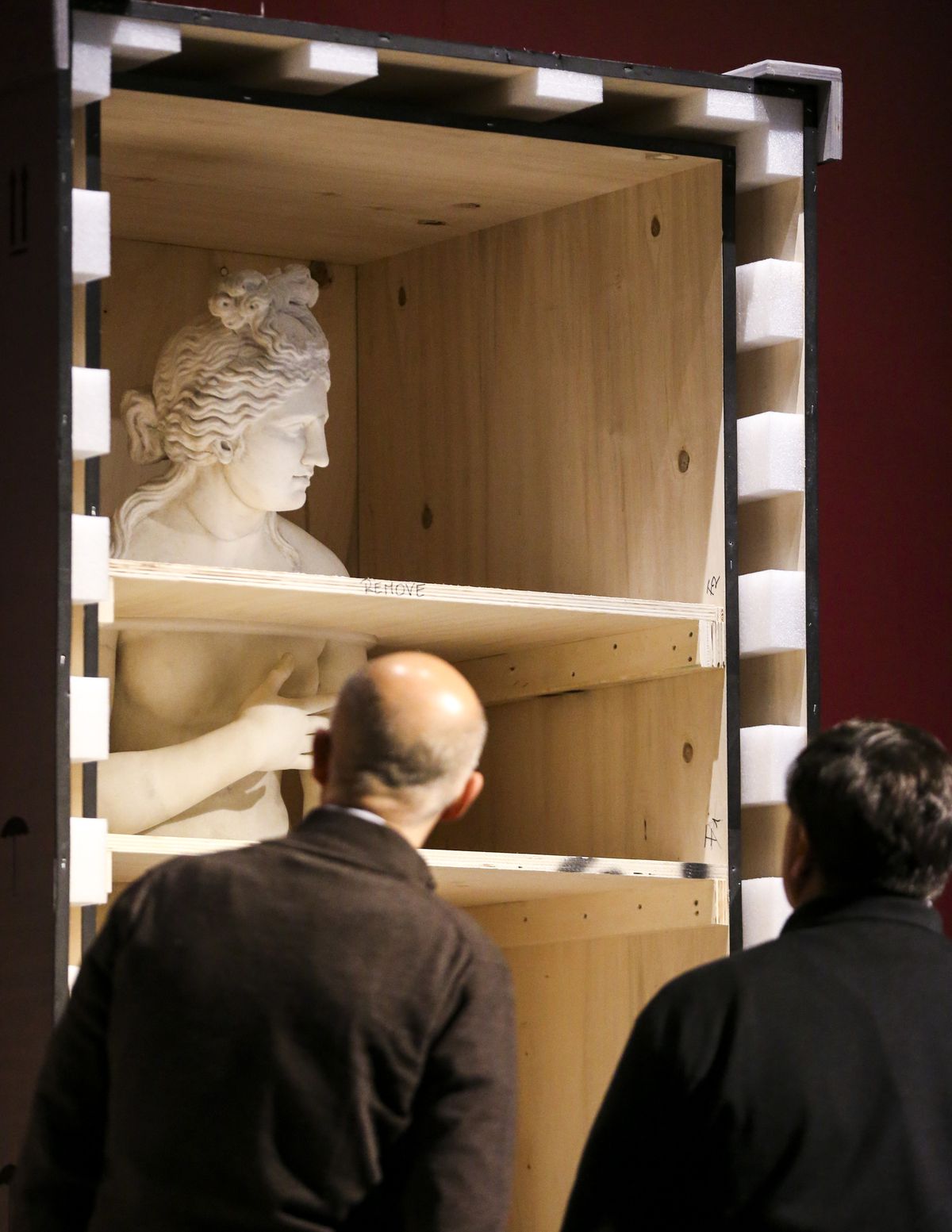 Pasquale Festinese, left, and Ciro Spina with the Museo Archeologico Nazionale Di Napoli in Italy, inspect the statue of Aphrodite for shipping damage after unboxing it as crews set up the traveling Pompeii exhibit at The Leonardo Museum in Salt Lake City on Monday, Nov. 18, 2019.