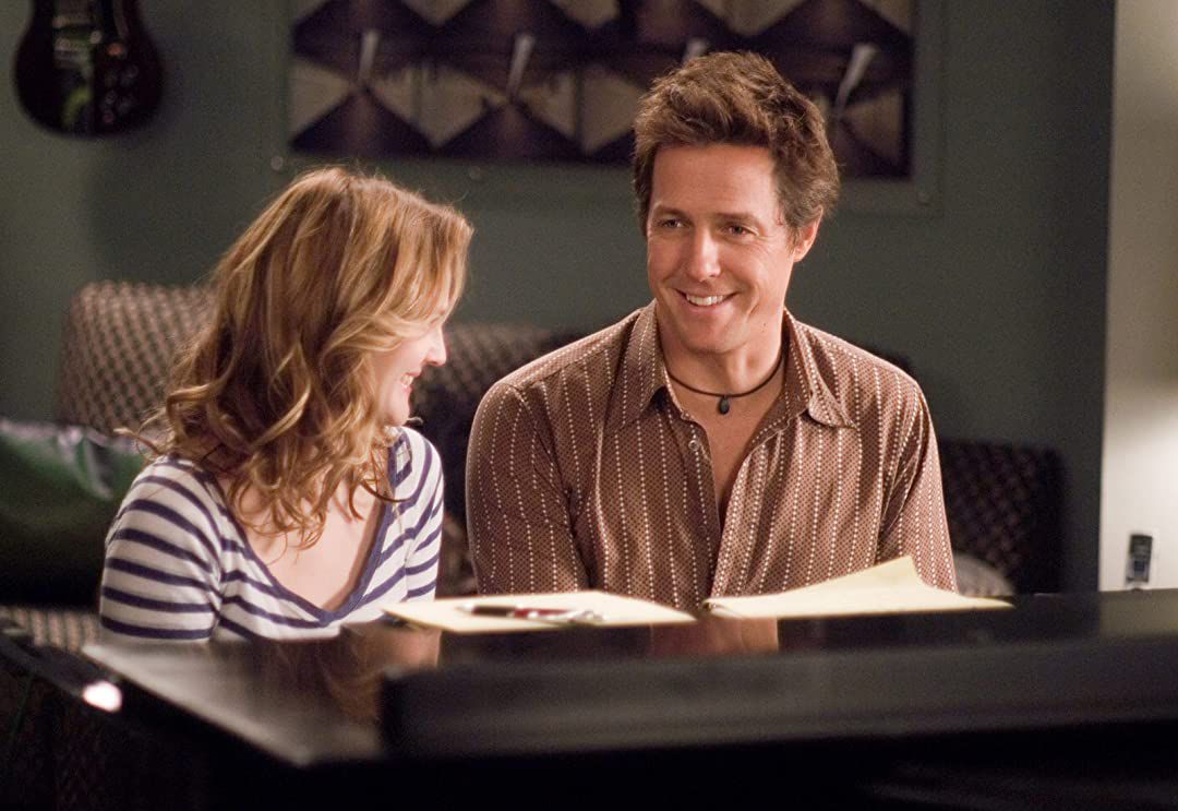 music and lyrics: hugh grant and drew barrymore sit at a piano and smile