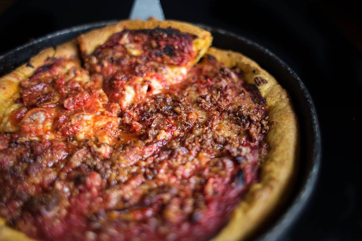 Deep dish pizza with a slice being pulled out.