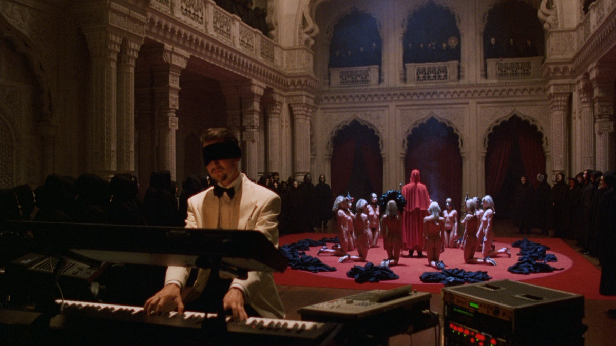 Todd Field plays the piano blindfolded as a cult ceremony takes place behind him in Eyes Wide Shut.