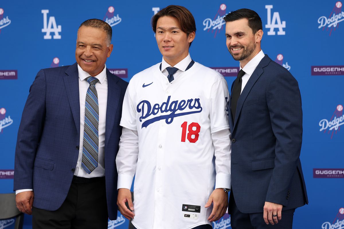 Newly acquired Los Angeles Dodgers pitcher Yoshinobu Yamamoto poses for a photo with manager Dave Roberts and general manager Brandon Gomes during an introductory press conference on December 27, 2023 at Dodger Stadium in Los Angeles, CA.