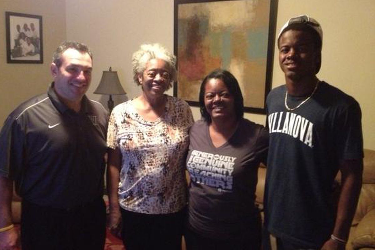 Trey Johnson (right) poses with his family and Villanova coach Roc Bellantoni (left) upon his official commitment to  the Wildcats.
