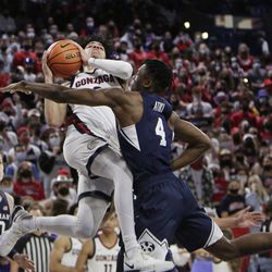 Gonzaga guard Julian Strother, left, drives to the basket and is fouled by BYU forward Ateki Ali Attiki during the first half of an NCAA college basketball game, Thursday, Jan. 13, 2022, in Spokane, Washington. 