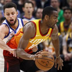 Utah Jazz guard Alec Burks (10) keeps the ball ahead of Golden State Warriors guard Stephen Curry (30) at Vivint Arena in Salt Lake City on Tuesday, Jan. 30, 2018.