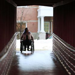 Stacy Davis-Stanford wheels between buildings at Westminster College where she is a student in Salt Lake City Thursday, Feb. 26, 2015. Davis-Stanford lacks health insurance and has a neurological disorder resulting from a car accident.  