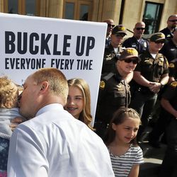 Justin Harding, Gov. Gary Herbert’s chief of staff, kisses his daughter Emme before a press conference encouraging seat belt use in Salt Lake City on Monday, May 23, 2016. Harding was driving kids to a Utah Youth Symphony Orchestra rehearsal at the David P. Gardner Hall when they were hit, head on, in January of 2016.