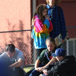 A group of students stand across the street across the street from Union Middle School in Sandy as police investigate the shooting of a 16-year-old boy on Tuesday, Oct. 25, 2016.
