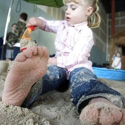 Deja Cloward, 4, plays in the sand during a Baja California beach party at Rubio's Fresh Mexican Grill on Saturday, Jan. 30, in Salt Lake City, Utah. The indoor beach party featured sand, music, games, coastal scenery and fresh food. The event  benefited the Best Buddies program. 