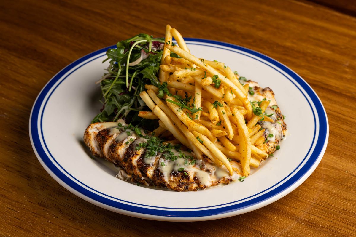 Sous vide French chicken with cajun spices, herb blend, fries, and arugula salad at Hudson House restaurant in West Hollywood, Calfiornia.