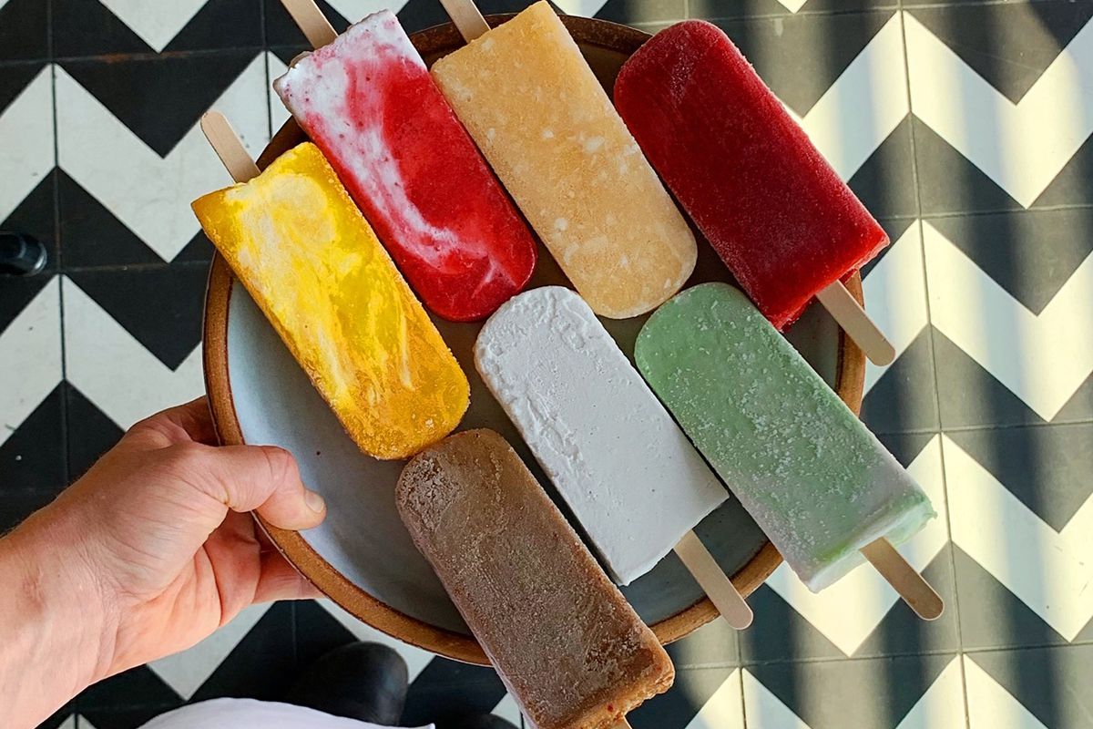 A plate of colorful popsicles against a black-and-white zigzag patterned background