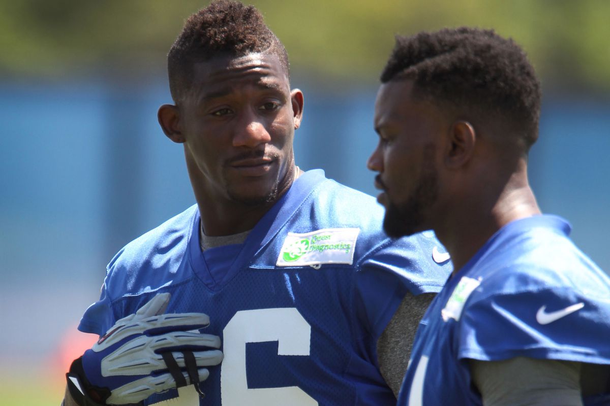 Antrel Rolle (left) talks to Walter Thurmond during mini-camp