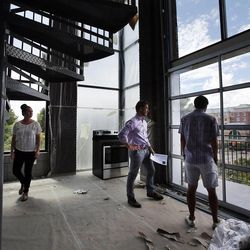 Olympic speedskater J.R. Celski, right, takes in the view as he looks at units at Broadway Park Lofts in Salt Lake City, Thursday, July 10, 2014. At left are Brian Tripoli of City Home Collective and Erin Behunin of Broadway Park Lofts.