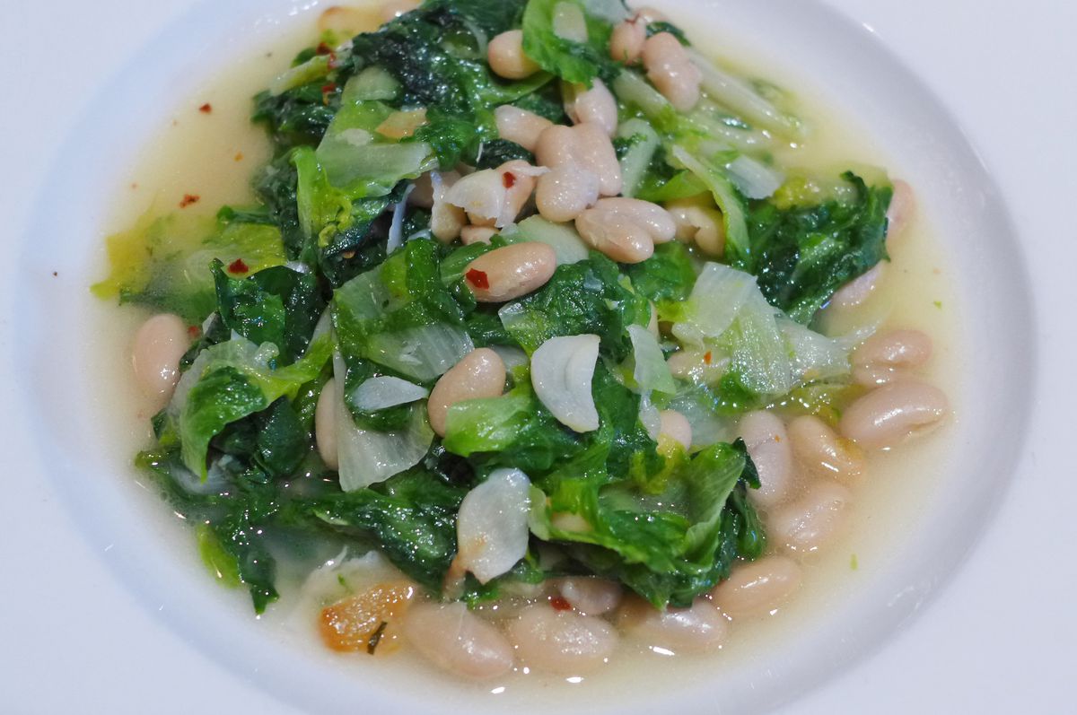 A bowl of escarole and white beans in thick broth.