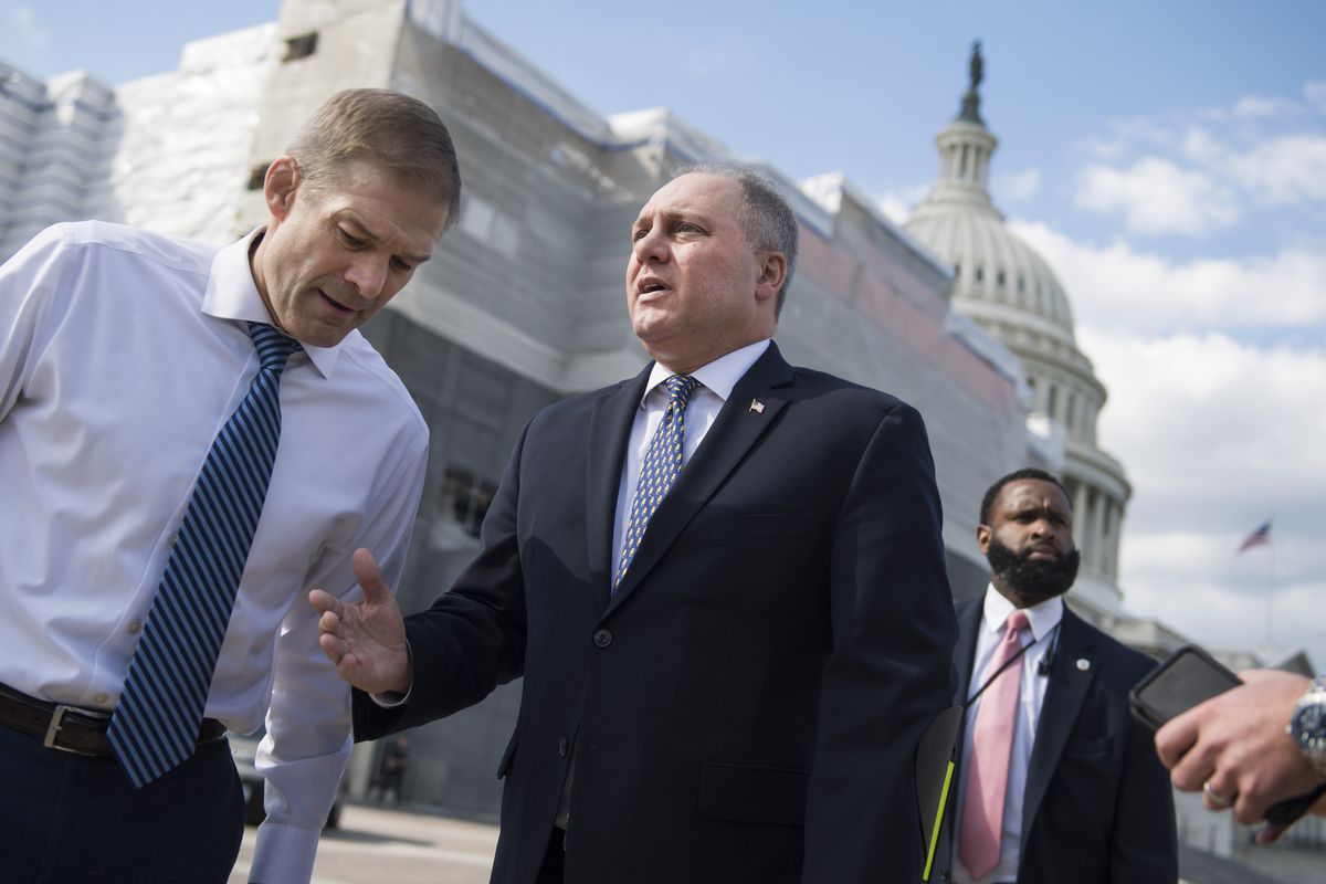 Scalise, his thinning grey hair clipped short, gestures towards Jordan on a sunny day, the Capitol dome looming behind them. Scalise wears a dark suit and blue and white tie; Jordan, as is his habit, is jacketless in a white shirt and blue and black striped tie.