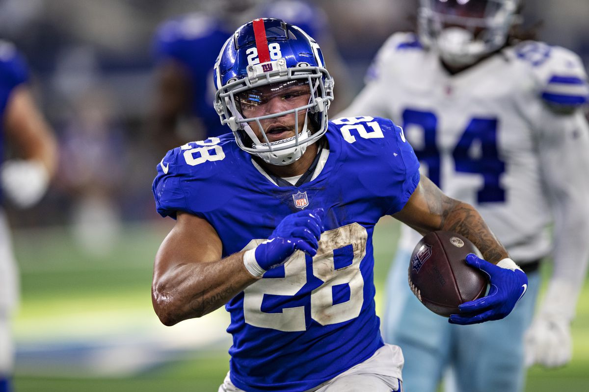 Devontae Booker #28 of the New York Giants runs the ball during a game against the Dallas Cowboys at AT&amp;T Stadium on October 10, 2021 in Arlington, Texas. The Cowboys defeated the Giants 44-20.