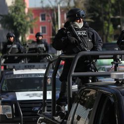 Federal police patrol as part of increased security outside the SEIDO, the organized-crime division of Mexico's Attorney General Office where high profile detainees are sometimes shown to the press in Mexico City, Friday, Feb. 27, 2015. The leader of the Knights Templar cartel Servando "La Tuta" Gomez," one of Mexico's most-wanted drug lords, was captured early Friday by federal police in the capital city of Morelia, according to a Mexican official. It could not be confirmed if Gomez was inside the SEIDO building. 