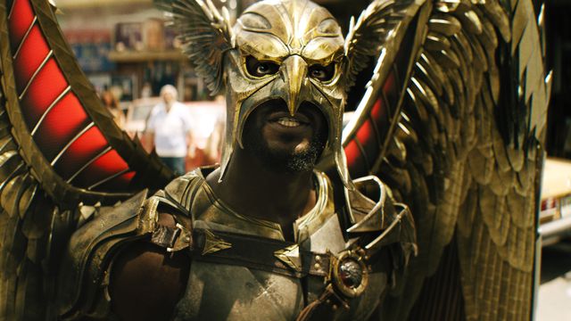 Aldis Hodge as Hawkman in Black Adam. He’s wearing his outfit: An armored chestpiece, a hawk-like helmet that masks the top of his face, and a set of huge metal wings.