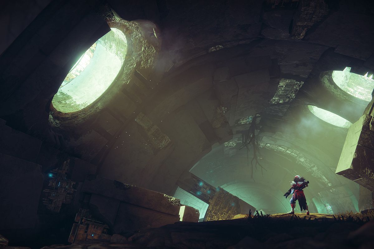 A Guardian player in Destiny 2 stands in the overgrown ruins of an old station, looking out a window draped in natural greenery towards the sunlight.