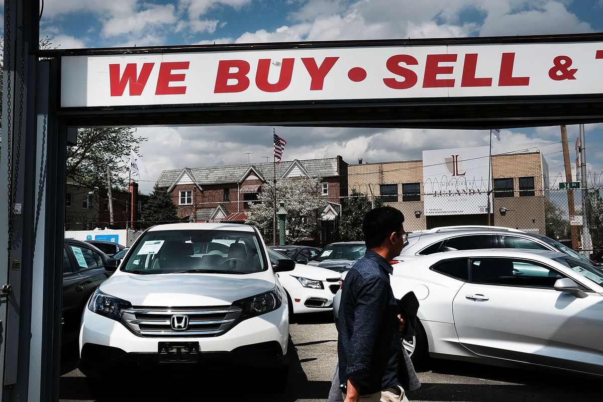 A used car lot with a sign reading “We buy - sell”