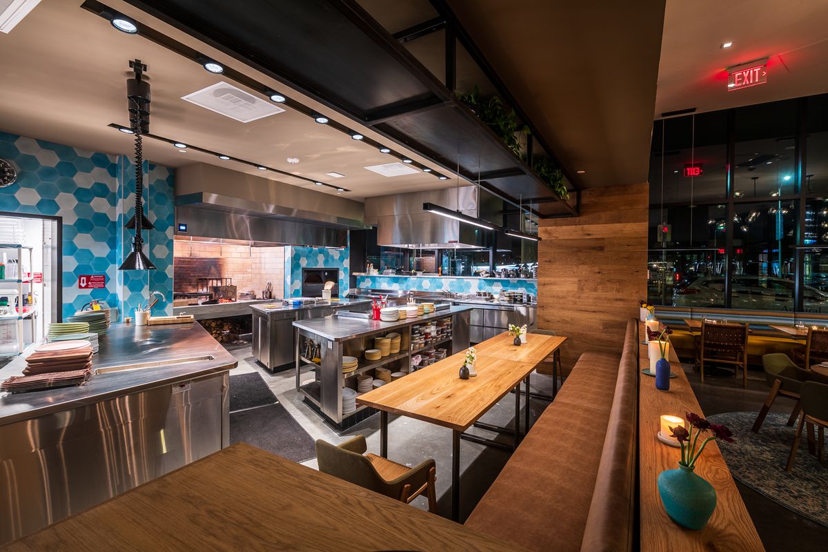 Albi’s open kitchen includes a live-fire hearth for grilling kebabs and a wood-burning oven near a chef’s tasting table