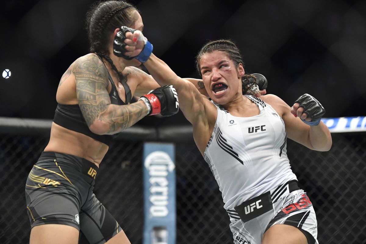 Julianna Pena punches Amanda Nunes of Brazil in their women’s bantamweight championship bout during UFC 269 at T-Mobile Arena