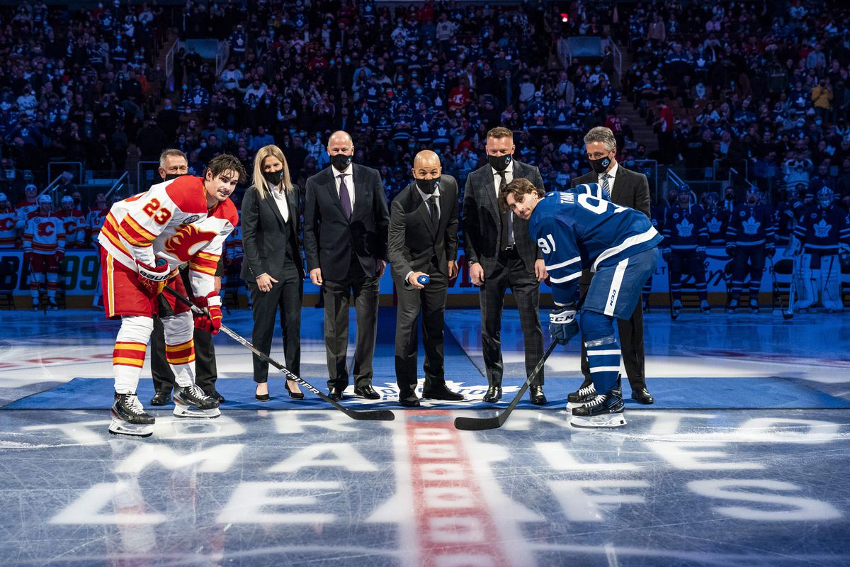 Hockey Hall of Fame Class of 2020 Inductees (from left to right rear) Ken Holland, Kim St-Pierre, Kevin Lowe, Jarome Iginla, Marian Hossa and Doug Wilson take part in a ceremonial face-off between Sean Monahan #23 of the Calgary Flames and John Tavares #91 of the Toronto Maple Leafs at the Scotiabank Arena on November 12, 2021 in Toronto, Ontario, Canada.