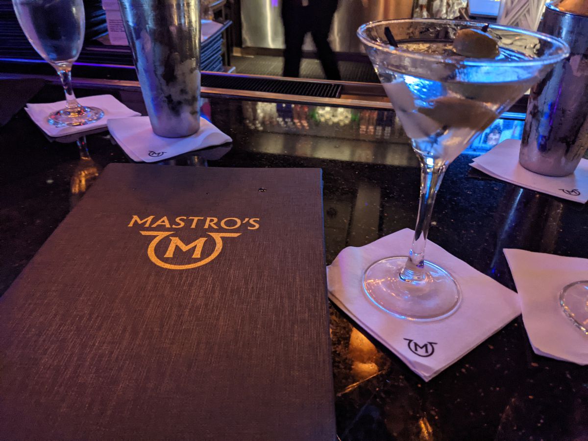 A martini next to a cocktail menu
