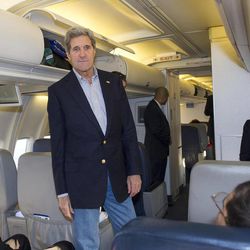 U.S. Secretary of State John Kerry talks to reporters traveling abroad with him shortly after finding out their aircraft had a mechanical problem before take off Saturday, April 6, 2013, at Andrews Air Force Base in Maryland. A backup aircraft was brought in to replace the plane. 