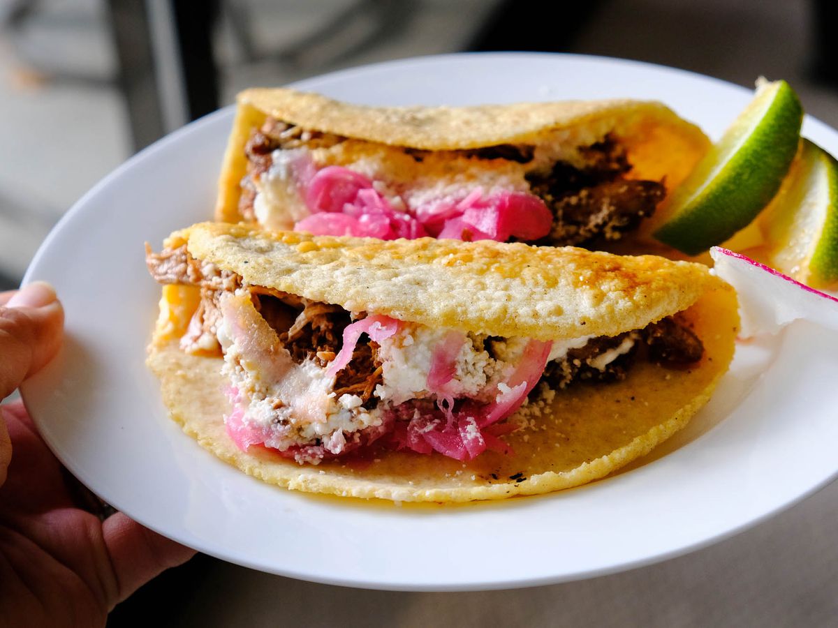 Two tacos on a plate at Little Neon Taco