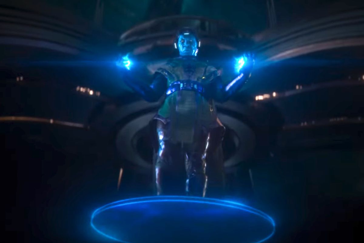 Kang appears hovering on a platform in green and purple armor with his hands glowing and a mask projecting a blue screen over his face in the trailer for Ant-Man and the Wasp: Quantumania